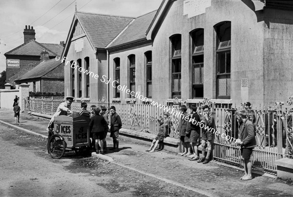 PARISH SCENE ICE CREAM SELLER ON BICYCLE OUTSIDE SCHOOL